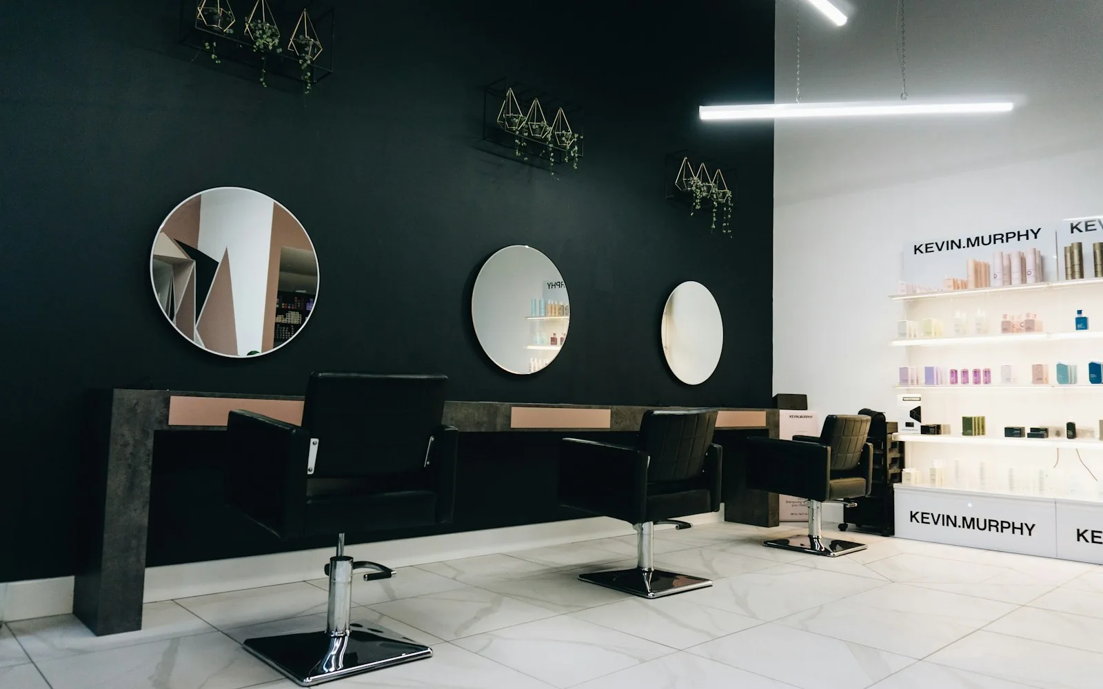 A refined salon interior with circular mirrors and deep green walls