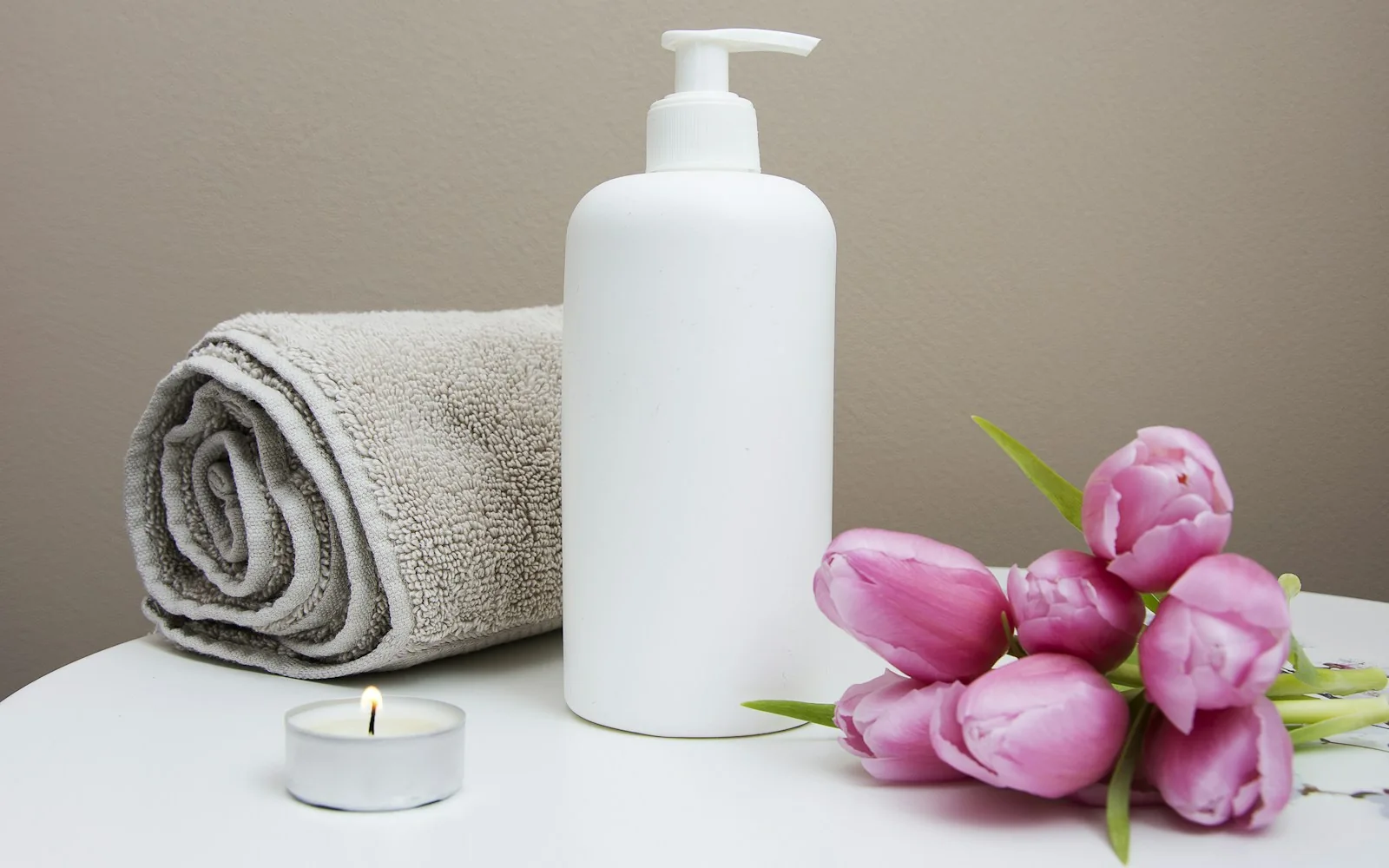 Soft spa towels, orchid flowers and a treatment bottle