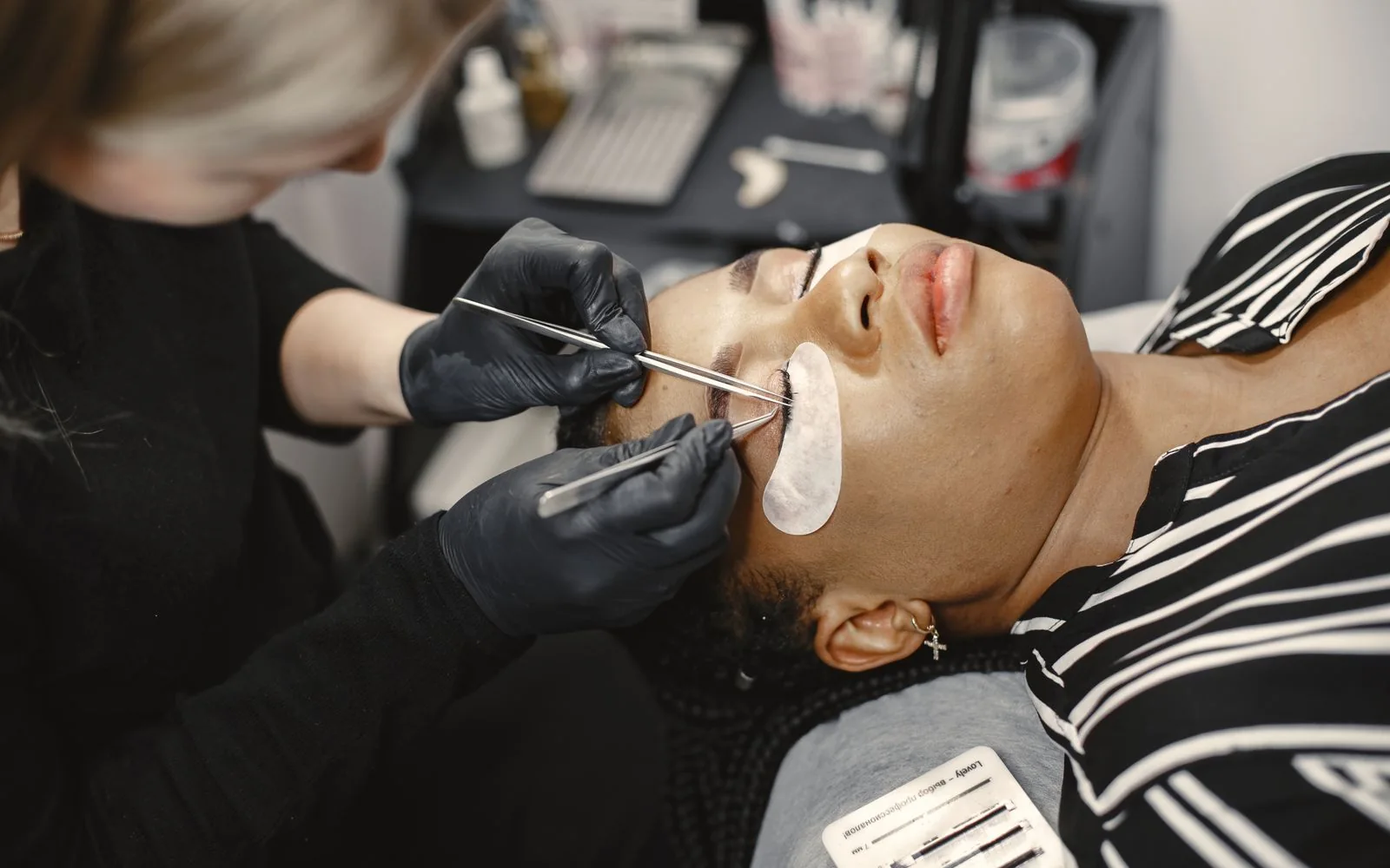 A lash technician carefully applying eyelash extensions