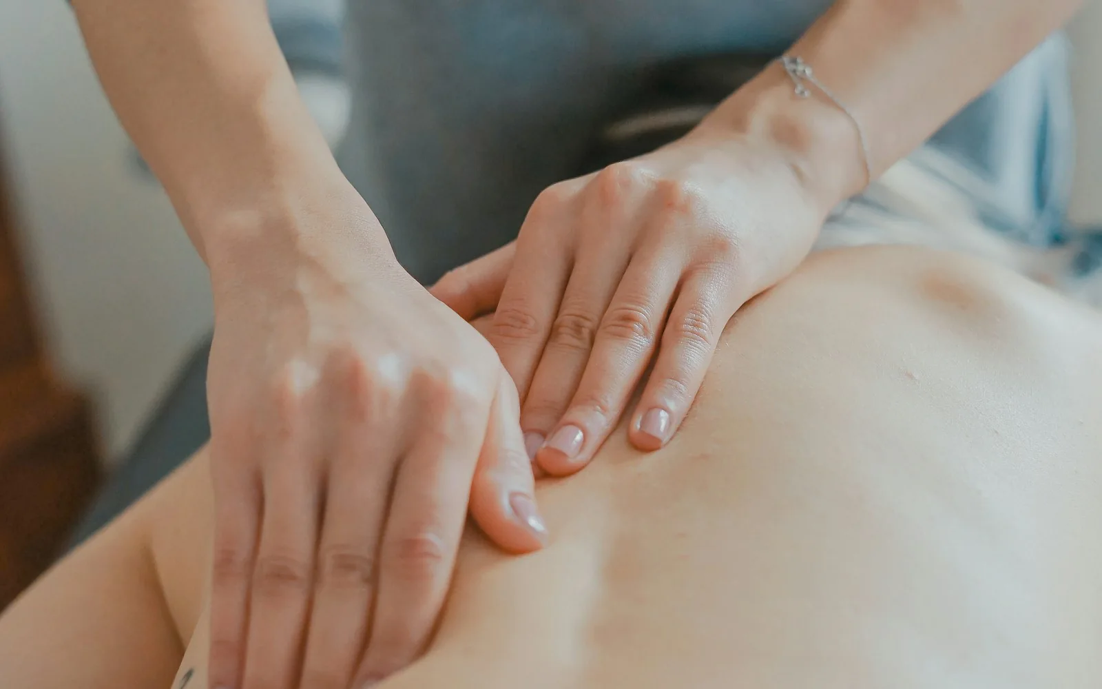 A massage therapist working on a client’s shoulders