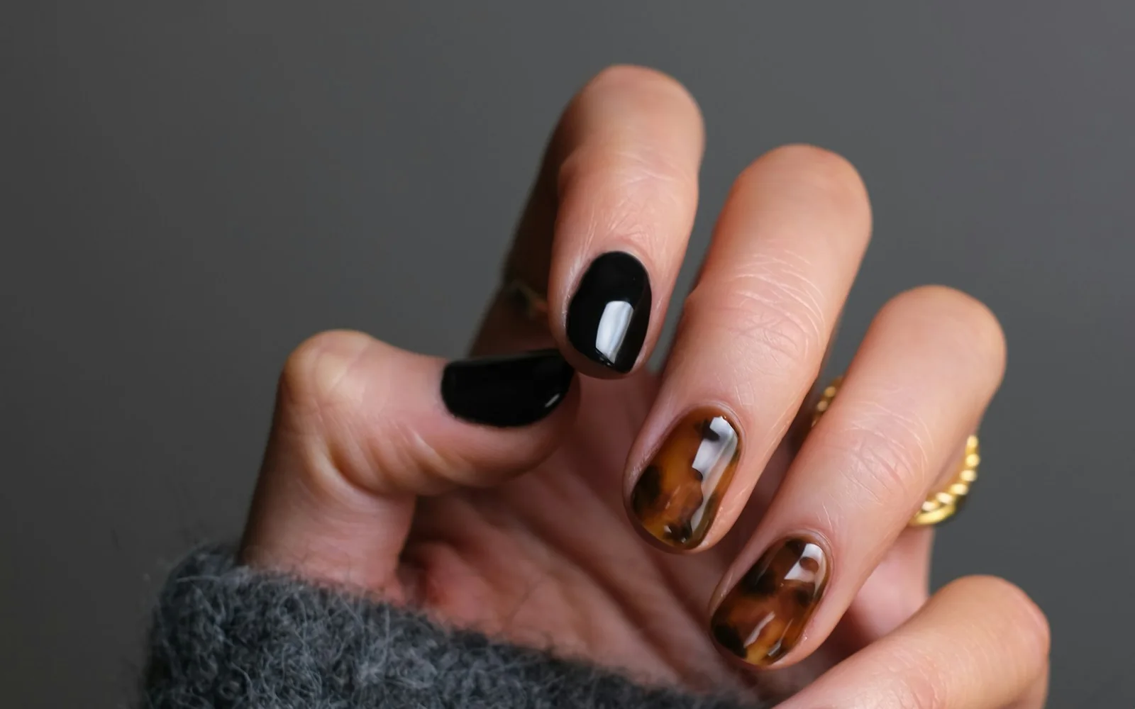 Close-up of polished nail art with a dark manicure