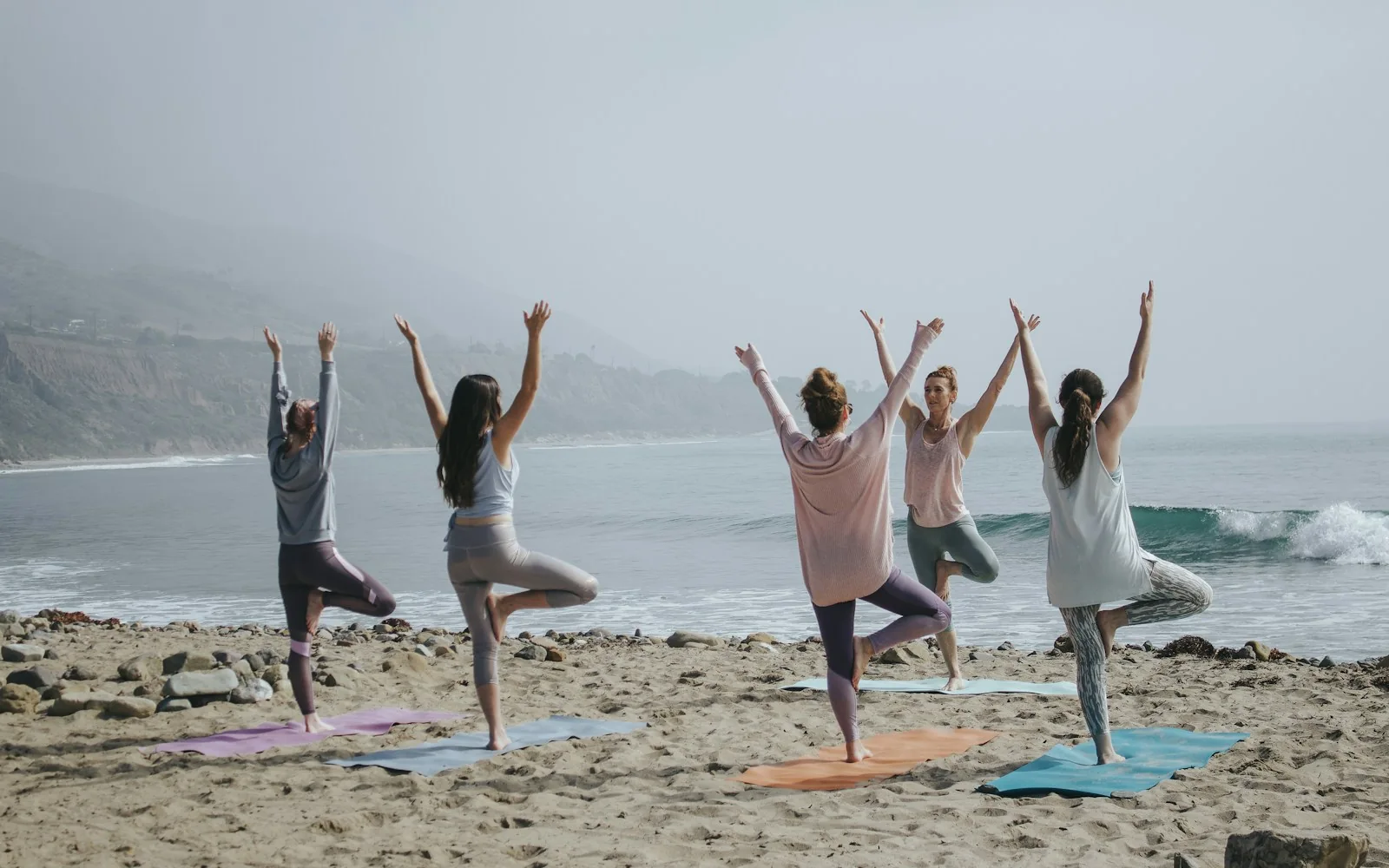 A group wellness session on a quiet beach